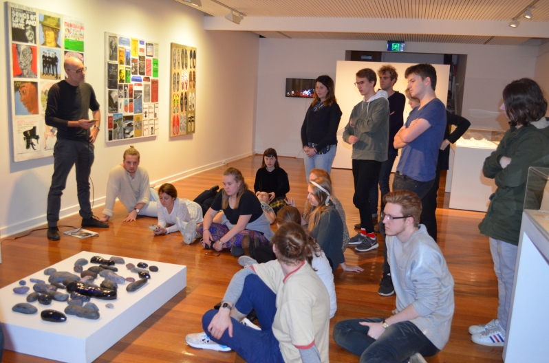 Dr Anthony Lyons and students at The George Payton Gallery listen to compositions in response to works in the exhibition. 